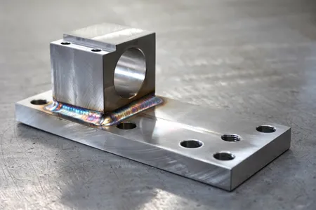 TIG welded stainless steel bracket: a machined, bored block fillet welded to a drilled mounting plate