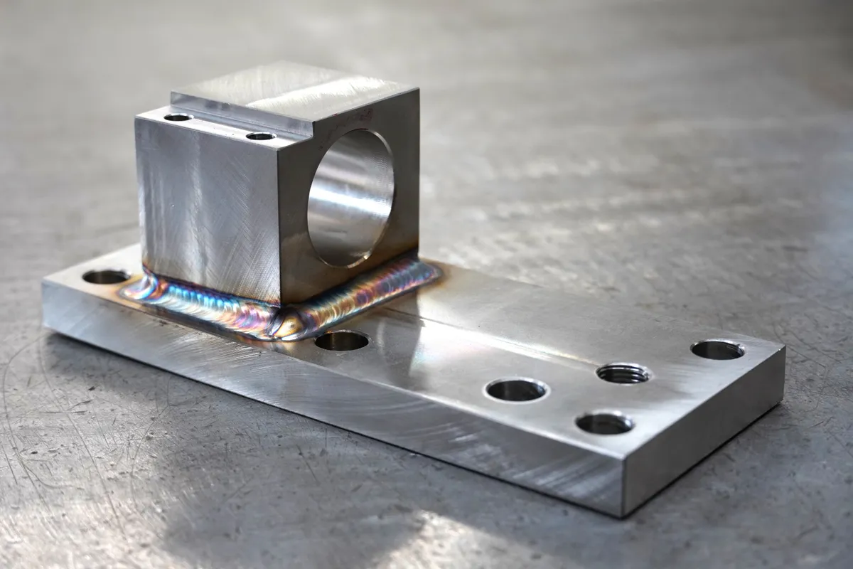 TIG welded stainless steel bracket, a machined and bored block fillet welded to a drilled mounting plate