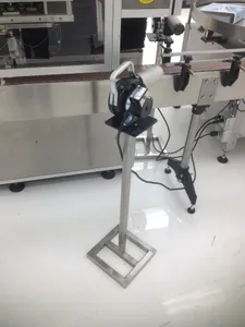 Stainless steel equipment stand with a welded square base on a production line