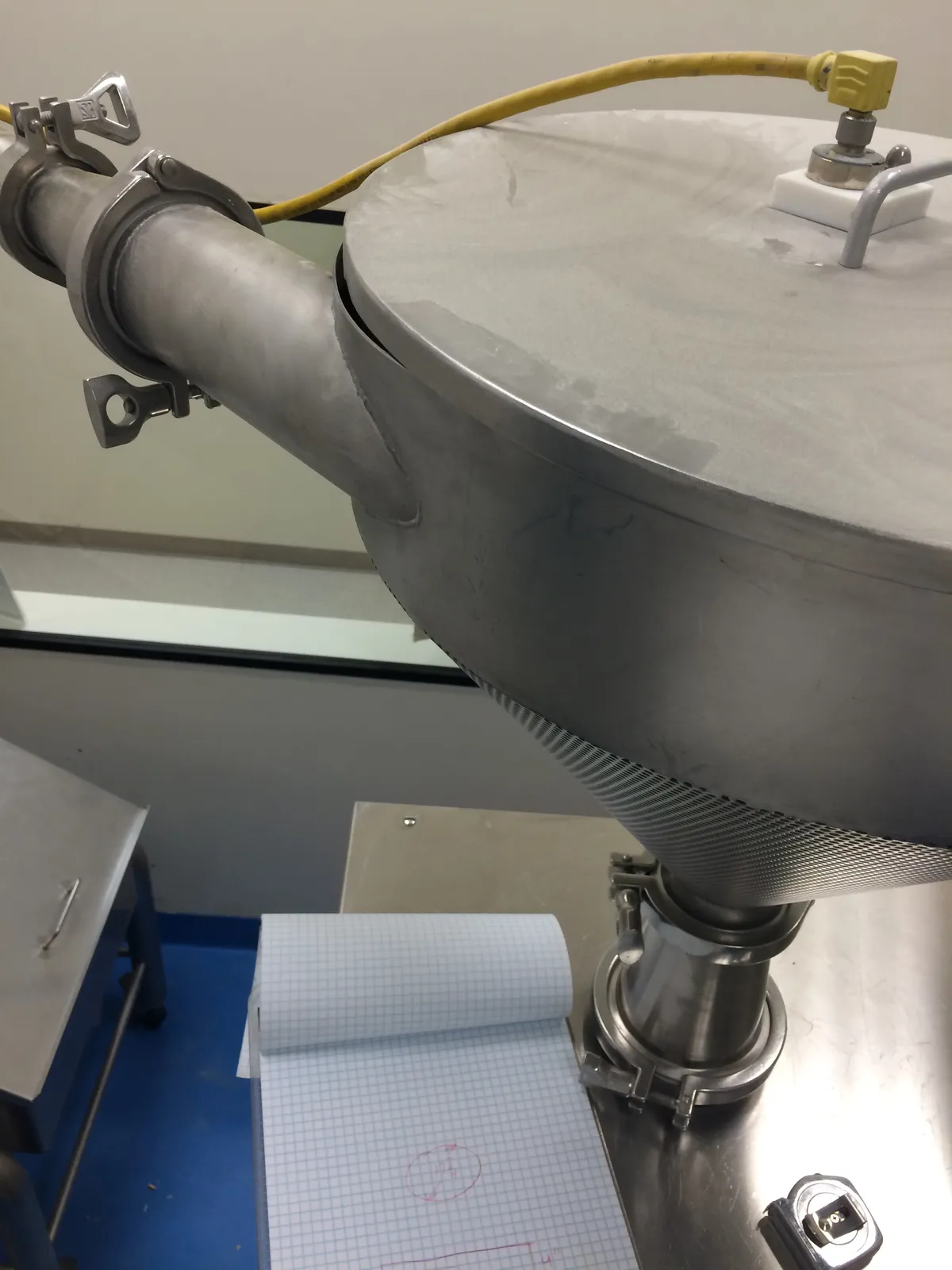 Stainless steel hopper with a perforated cone, angled inlet pipe and sanitary clamp fittings