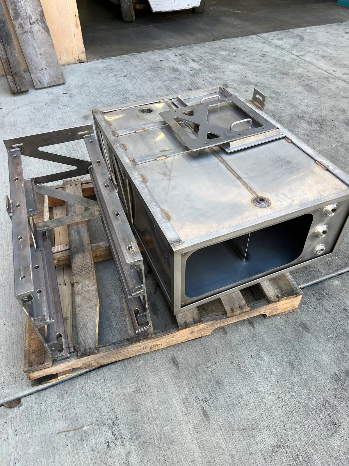 Fabricated stainless steel enclosure and frame sections on a pallet ready for delivery