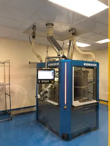 Tablet press installed in a pharmaceutical cleanroom with stainless ductwork overhead